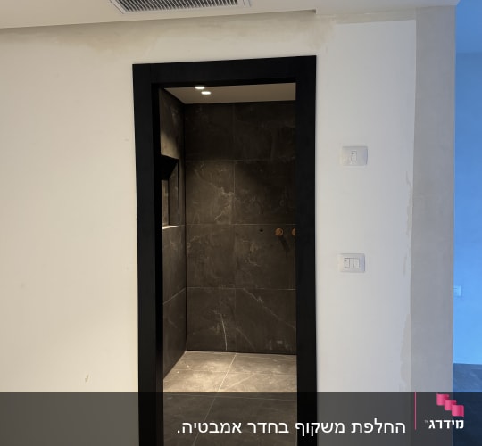 פתח דלת עם מסגרת שחורה וקירות אפורים